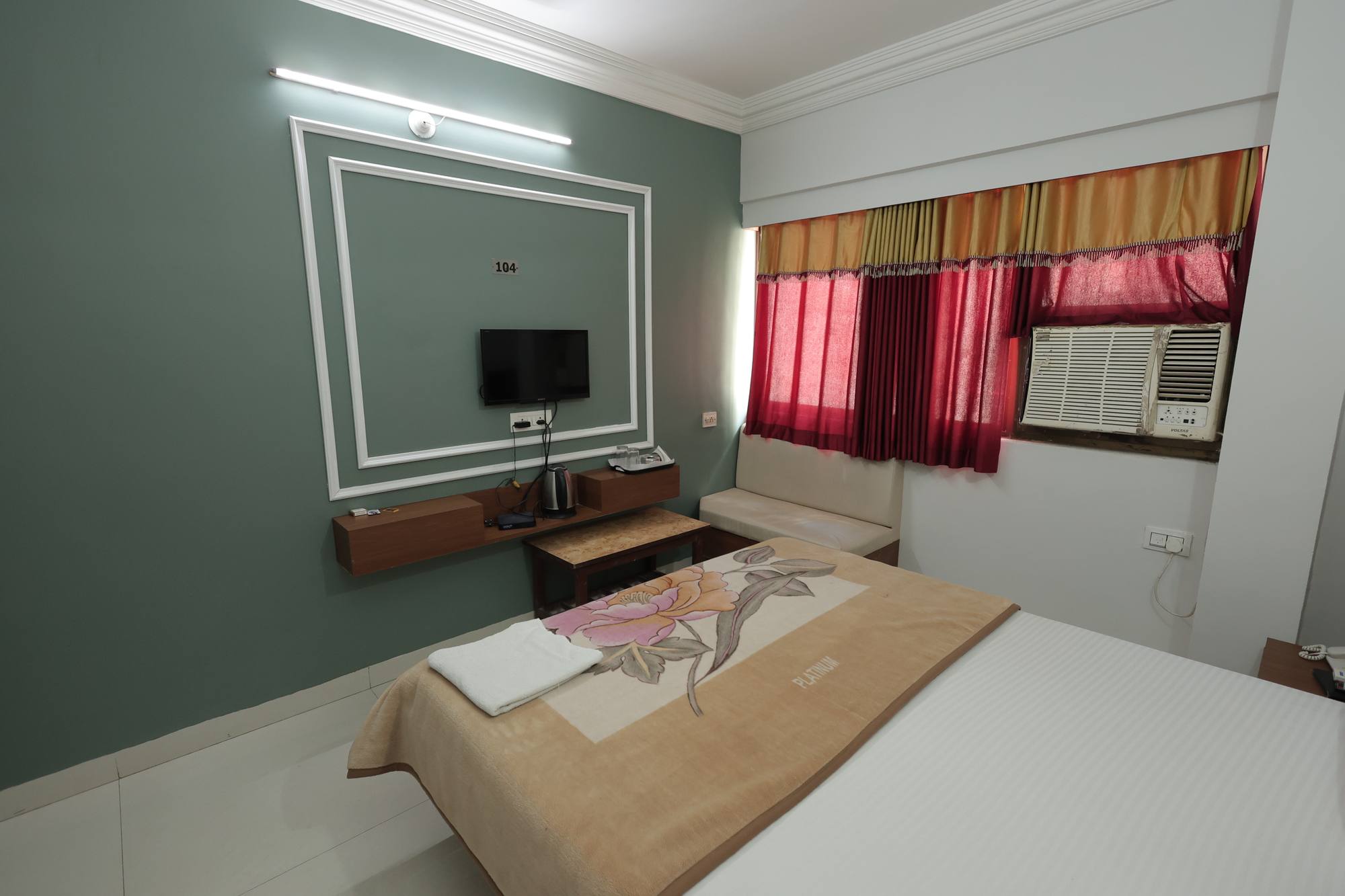 A second view of the AC Room at Hotel Relax Inn showing the seating and work surface