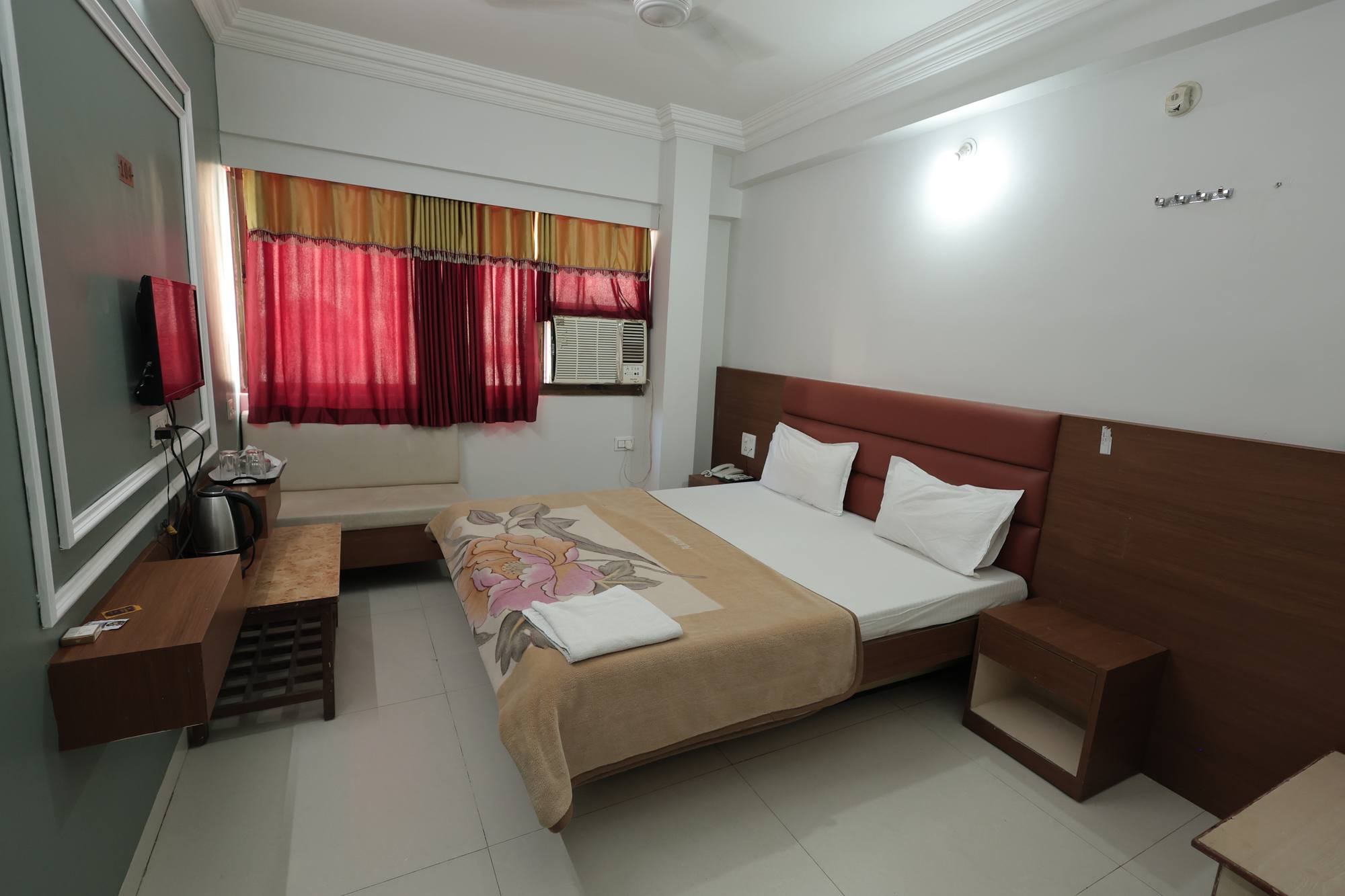The AC Room at Hotel Relax Inn, Banswara, with a king bed, television and seating by the window