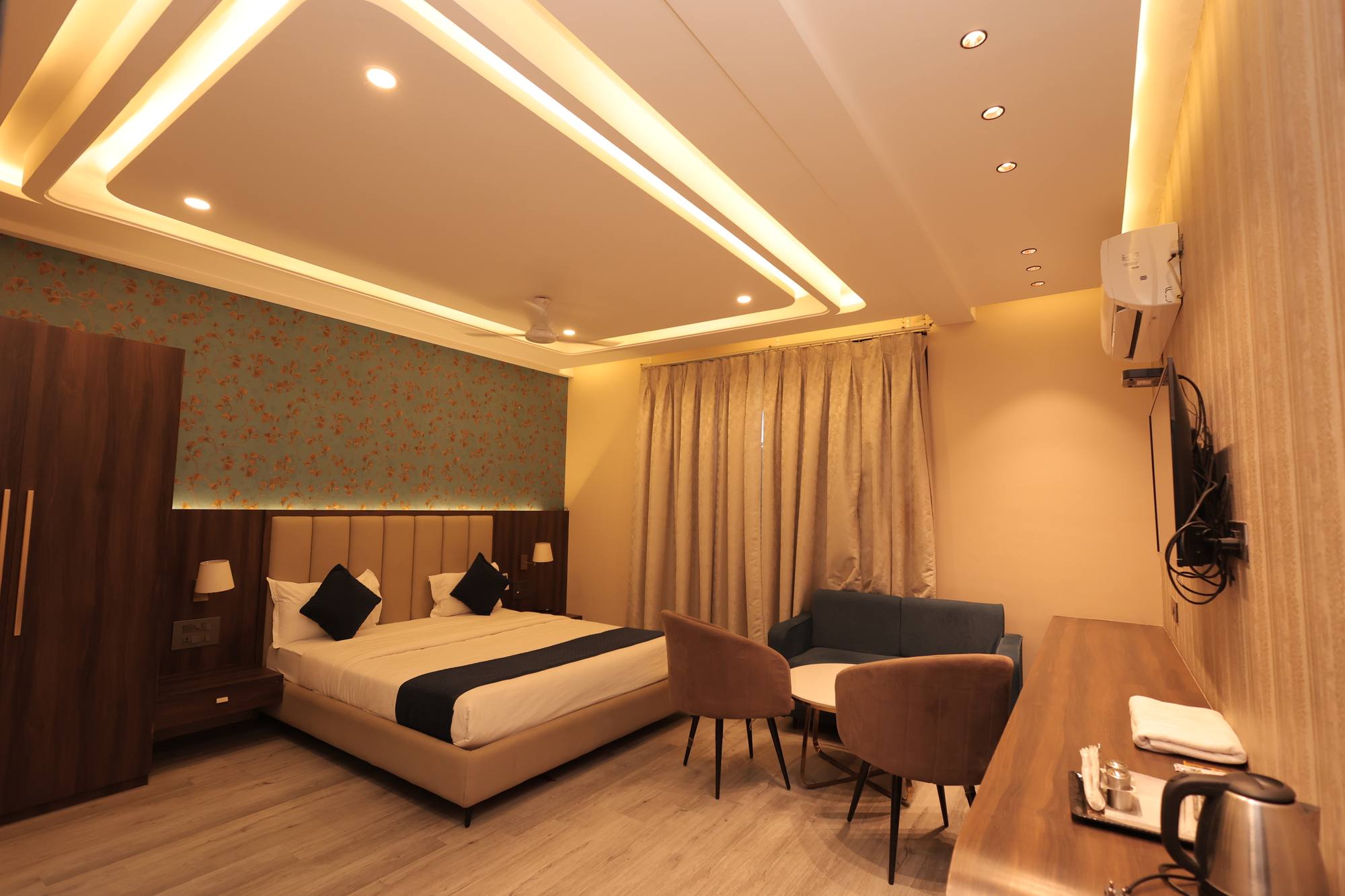 A further view of the Premium Room at Hotel Relax Inn showing the wardrobe and work desk